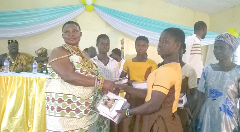 Nana Borfule Okogye presenting exercise books to a schoolgirl. Nana Borfule Okogye presenting exercise books to a schoolgirl.