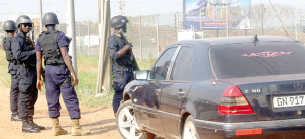 • Some of the young men who were there to calm the irate youth from further seizure of the toll booth. • Policemen protecting the car with the money. Pictures: SAMUEL TEI ADANO Invisible Forces take over toll booth
