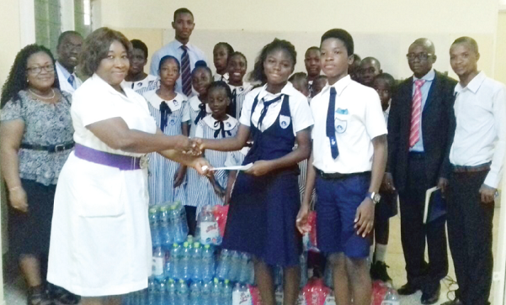 Two pupils of the school presenting the amount and items to Mrs Peace Asante. Two pupils of the school presenting the amount and items to Mrs Peace Asante.