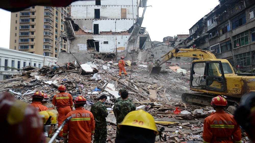 Rescue workers search the site where residential buildings collapsed in Zhejiang province Multiple building collapses in China kill at least 8