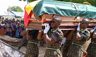 Pallbearers carrying the coffin with the remains of AICOI Cosmos Dakurah, their slain colleague, to the cemetery