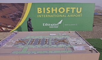 A member of the Ethiopian Federal Police walks past the Bishoftu International Airport design during its construction commencement in Abusera, Ethiopia, January 10, 2026. REUTERS/Tiksa Negeri