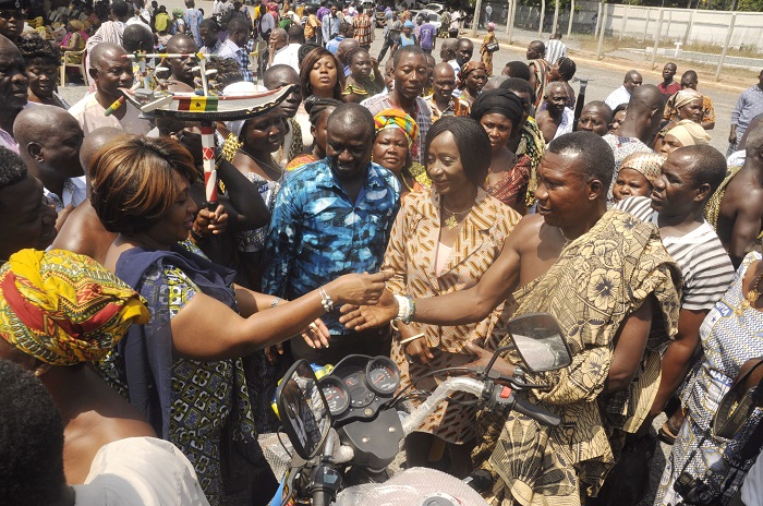 Mrs Sedinam Tamakloe Ationu (2nd left), Chief Executive Officer of MASLOC, handing over the key to one of the tricycles to Nene Foklo Anyakpor (2nd right), a beneficiary from Ada at the handing over ceremony in Accra. Looking on is Ms Sherry Ayittey (3rd right), the Minister of Fisheries and Aquaculture Development, and other beneficiaries. INSET: Some of the tricycles for the fisherfolks. Picture: GABRIEL AHIABOR