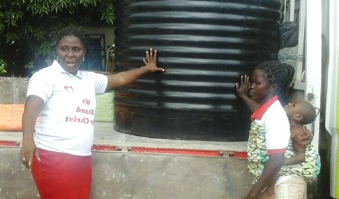 Ms Rosemary Ladzi receiving the water-tank. Ms Rosemary Ladzi receiving the water-tank.