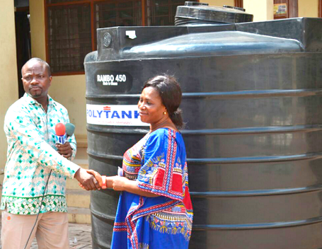 Mr Angenu (left) presenting a water tank to a beneficiary Mr Angenu (left) presenting a water tank to a beneficiary