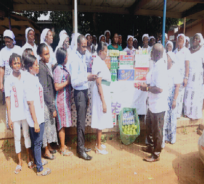 Pastor Christian Bampoe (right), Pastor of the Royal Assembly, presenting items on behalf of the Women's Movement of the Church to Madam Lydia Agbeko (5th left ) Principal Nursing Officer of the Tema General Hospital