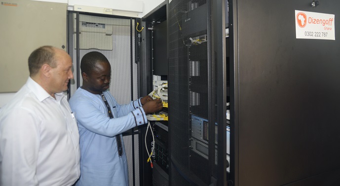 Mr Michael Adjei Takyi, Principal Programmnes Manager of the  Ghana Investment Fund for Electronic Communications (GIFEC) explaining the operation of the satellite hub. On his right is Mr Patrick Attia, General Manager, Communication of Dizengoff Ghana. INSET: The satellite dish. Picture: EMMANUEL QUAYE