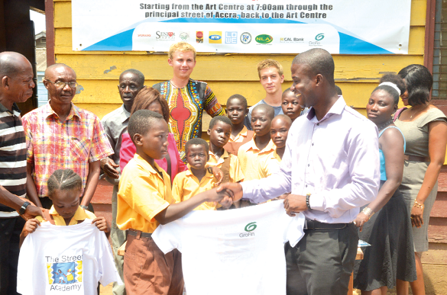 Mr Abraham Mensa-Belley presenting shirts to one of the children of the academy Mr Abraham Mensa-Belley presenting shirts to one of the children of the academy