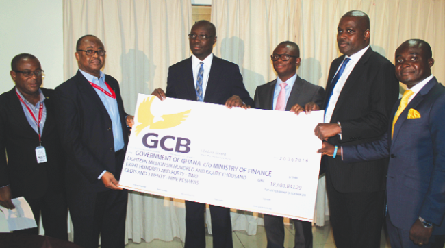Mr Socrates Afram (3rd right), Chief Finance Officer, GCB Bank Limited, presenting a dummy cheque to Mr Casiel Ato Forson (3rd left), a Deputy Minister of Finance, during the ceremony. Those with them are some officials from the GCB Bank Limited and the Ministry of Finance. Picture: EDNA ADU-SERWAA GCB Bank Ltd pays GH¢18.7m dividend to govt