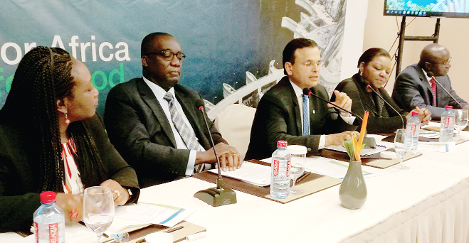 Mr Sunil Kaushal (middle) addressing the news conference. To his left is Mr Kweku Bedu-Addo Stanchart to concentrate on organic growth in Africa
