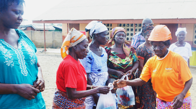 Madam Vanderpuiye (right) presenting items to her assistants to mark her celebration 76 Year old woman marks 15th anniversary in waste collection