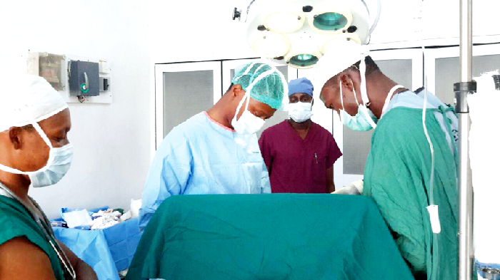 A team of doctors and paramedics performing surgery on a hernia patient A team of doctors and paramedics performing surgery on a hernia patient
