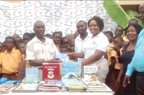 Ms Joyce Phyllis Ampofo, CEO, Rainbow Trust Foundation, presenting the books to the Headmaster of Klagon TMA  ‘A’ and ‘B’ Basic School, Mr Frederick Owusu