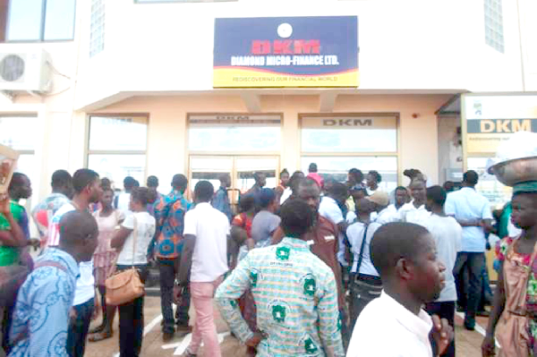 Some worried customers of DKM Microfinance company at its premises.