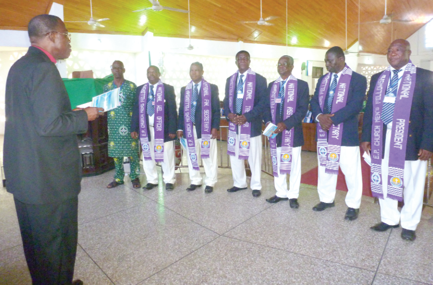• Very Rev. Amenu (left) performing the induction rites for the elected executive officers (right) 