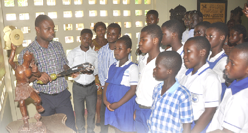 Mr Justice Brown (left), Curator at the Komfo Anokye Sword Site, showing the club members a sword similar