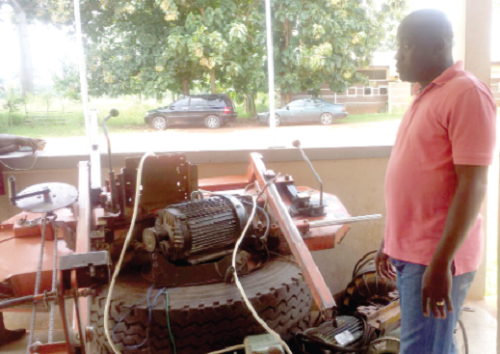 Nana Bosompim standing beside some of the dismantled machines belonging to the two sawmill companies