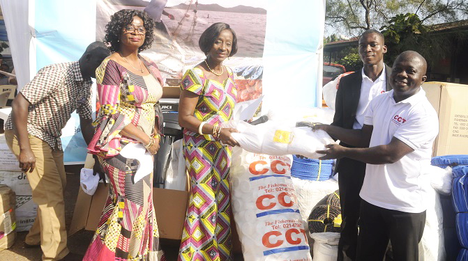 Mr Gyekye Twum-Ampofo (right), a representative  of the Continental Christian Trade Limited, presenting fishing inputs to Ms Sherry Ayittey (3rd left)