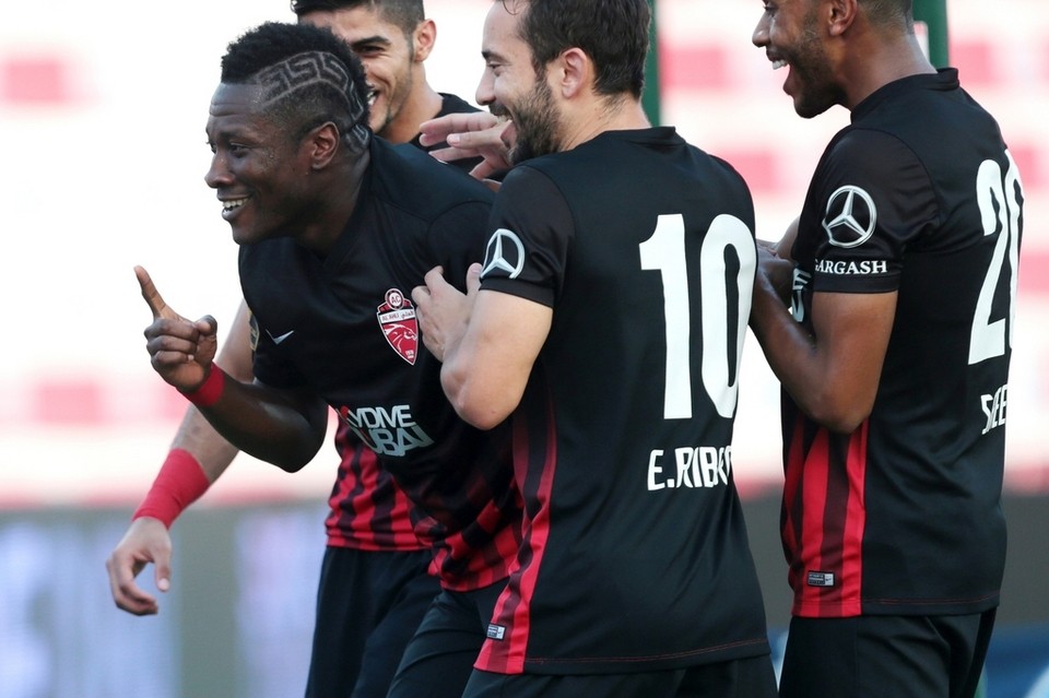 Al Ahli’s Asamoah Gyan, left, celebrates with teammates after scoring against Emirates during their Arabian Gulf League football match at the Rashid Stadium in Dubai