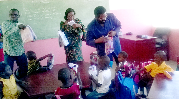 Dr Alfred Okoe Vanderpuije (arrowed) distributing some educational items to the children Dr Alfred Okoe Vanderpuije (arrowed) distributing some educational items to the children