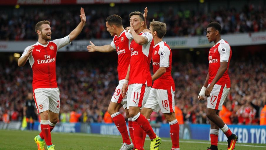 Arsenal players celebrating after Mesut Ozil's third goal EPL REVIEW: Arsenal batter Chelsea, Man United thrash Leicester, Man City stay perfect
