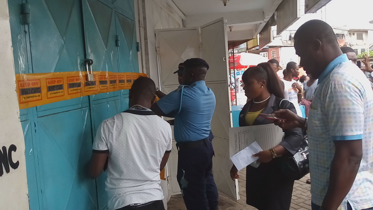Members of the Special Revenue Mobilisation Task Force closing some of the mobile phone shops at the Kwame Nkrumah Circle. Task force closes down 50 phone shops, arrests 2 for evading tax