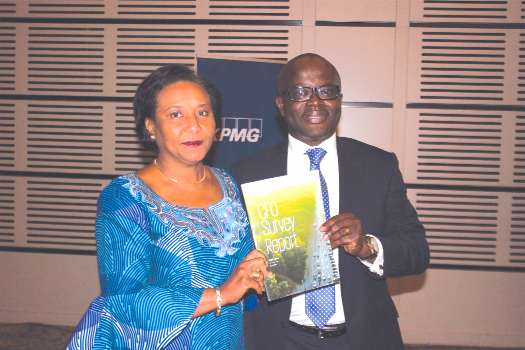 Mr Tola Adeyemi (right), Partner & head of Audit-KPMG Nigeria, being assisted by Mrs Mona Quartey, a Deputy Minister of Finance, to launch the CFO Survey Report in Accra. Picture: NII MARTEY M. BOTCHWAY Ghana will not overspend this year - Mona Quartey