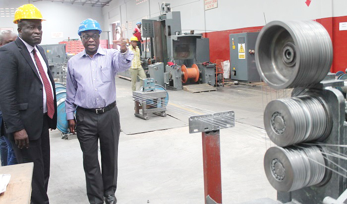 Mr Tony Oteng Gyasi (right), Managing Director of Tropical Cable and Conductor Limited explaining to Nii Kwartei Titus Glover (left), Deputy Minister of Transport on how cables are packaged after production during a tour of the facility after the meeting. Picture: EDNA ADU-SERWAA