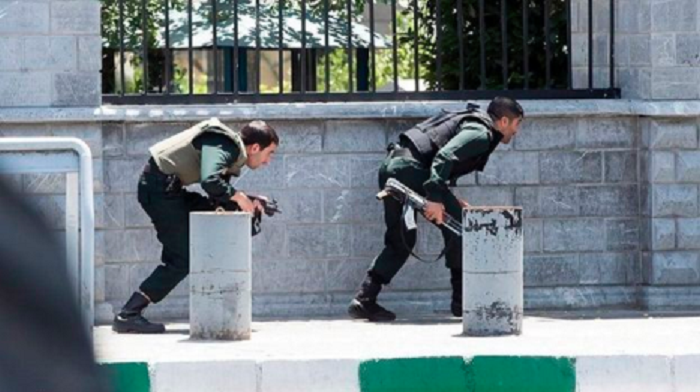 Iranian forces take cover as they surround the parliament building Iranian forces take cover as they surround the parliament building