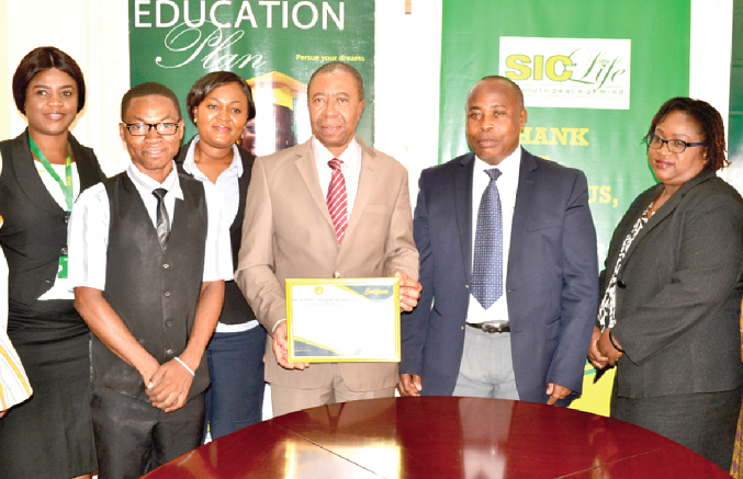 Mr Ananfure displaying his award. With him are some staff members of the company Mr Ananfure displaying his award. With him are some staff members of the company