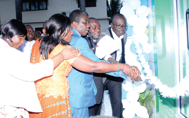  Some board members assisting the District Minister of the Presbyterian Church of Ghana, Kwashieman, Rev Samuel Nortey Adjei, to cut the tape to officially outdoor the facility. (INSET) The new office building.