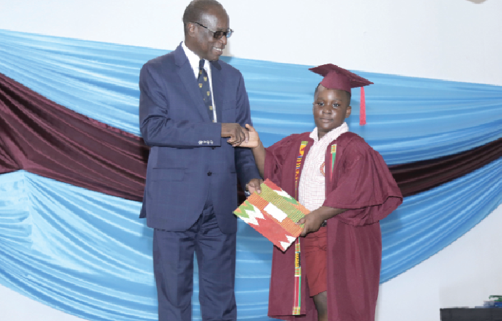 Mr Kabral Blay Amihere presenting an award the overall best graduating KG2 pupil, Nathan Jayden Ofori Boateng
