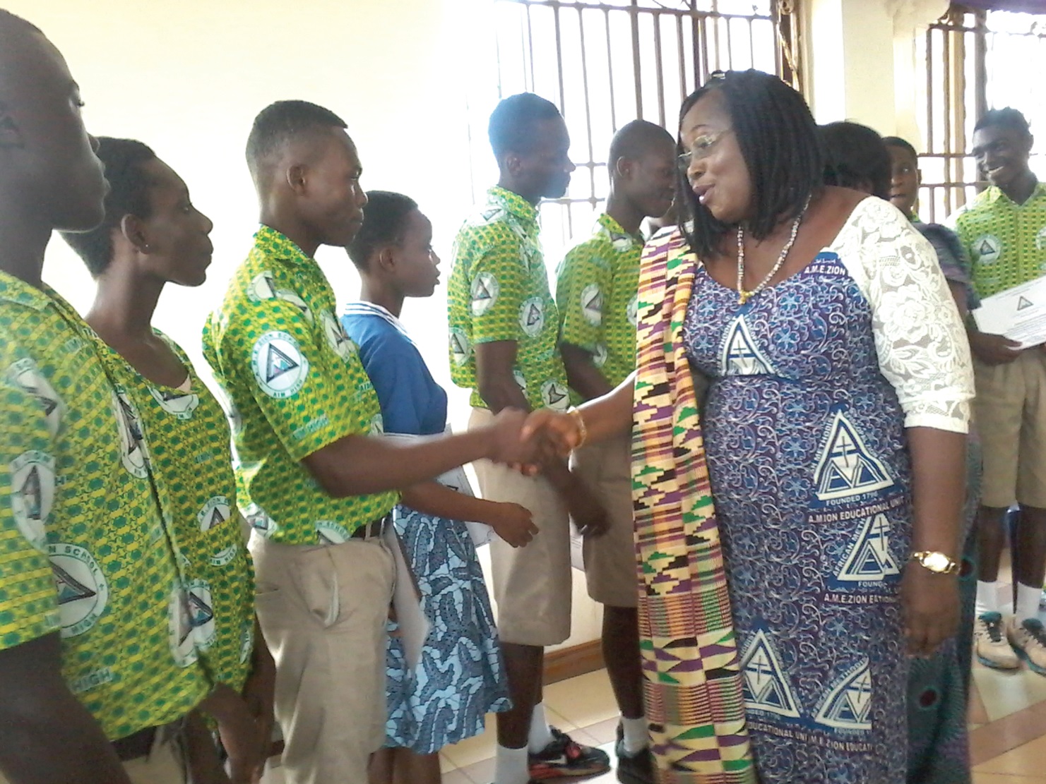 Mrs Evelyn Boakye-Mensah Zormelo, General Manager of the AME Zion Schools, shaking hands with one of the students while the others look on Mrs Evelyn Boakye-Mensah Zormelo, General Manager of the AME Zion Schools, shaking hands with one of the students while the others look on