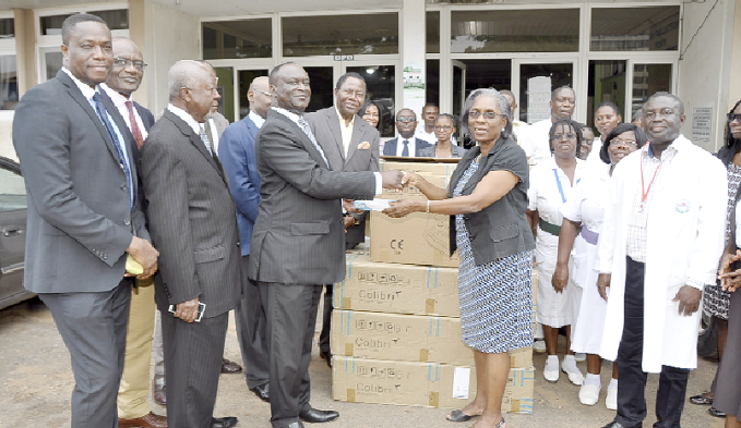 Mr Steve Kyerematen presenting the phototherapy equipment to Prof. Bamenla Goka, while officials from both the company and hospital look on