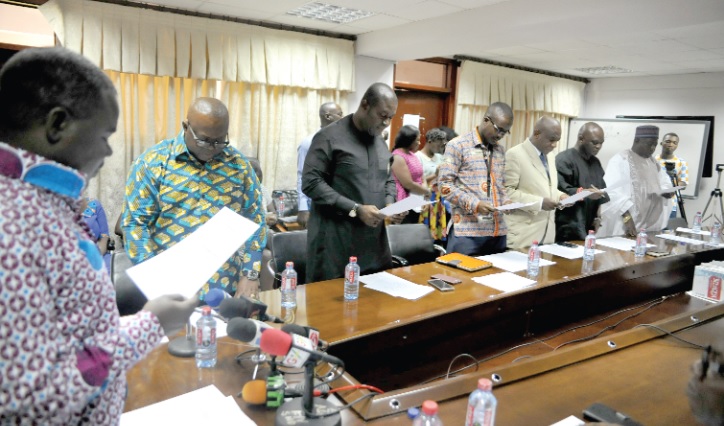 Mr Kwaku Asiamah (left) administering the official oath to the board members Intercity STC Coaches Limited Board of Directors inaugurated