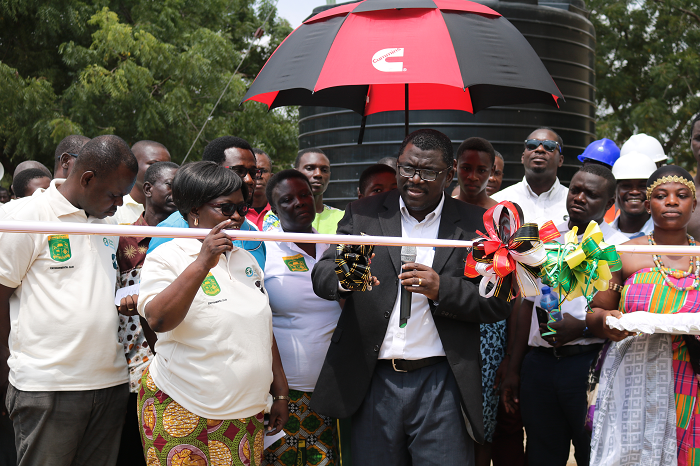 The Headmistress of Odorgonno SHS, Mrs Shine Ofori helping the GM of CWARO, Mr Aryeetey to cut the tape to inaugurate the facility