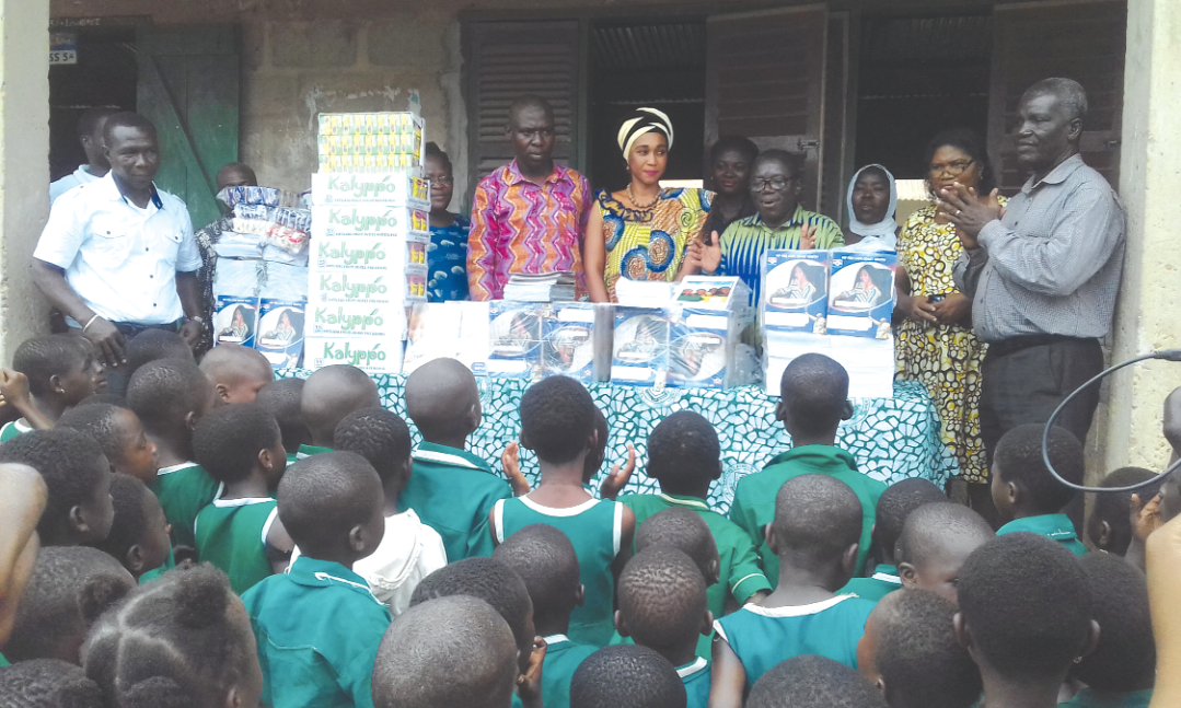 Mr Ernest Arthur, the Metro Chief Executive (left), Mrs Barbara Asher Ayisi (middle) and Mr Stephen Amoah (right) interacting with pupils and teachers of St Lawrence Catholic School