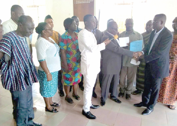 Mr William Bediako Asante (right), the DCE, receiving the report from Dr Kofi Afoakwa while other members of the committee look on Mr William Bediako Asante (right), the DCE, receiving the report from Dr Kofi Afoakwa while other members of the committee look on