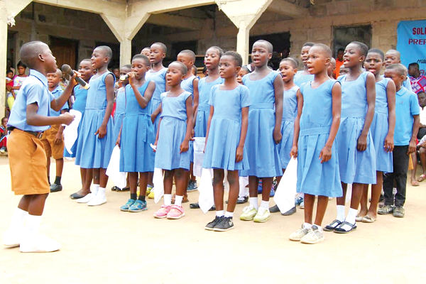 A section of the children singing at the ceremony. INSET: The cultural group getting ready for a performance.