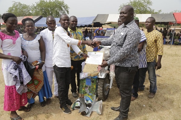  Mr George Ofori (right), DCE of Afram Plains South, presenting the overall best district farmer award to Mr Mboyo Tanuuno Johnson (3rd left) at the 34th National Farmers Day at Samanhyia in the Kwahu Afram Plains South District in the Eastern Region