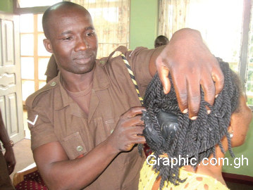 A prison officer retrieving concealed phone from a visitor’s hair A prison officer retrieving concealed phone from a visitor’s hair