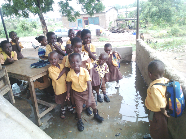 The pupils standing in the wet makeshift classroom after a rainfall. The pupils standing in the wet makeshift classroom after a rainfall.