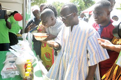 Participants examining some rice varieties displayed at an exhibition that formed part of the National Rice Festival. Among them is Nana Agyei Ayeh II (2nd right). Picture: EBOW HANSON