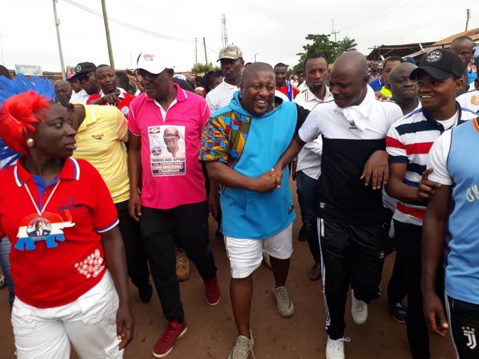 Nana Boakye (middle) and Abronye DC holding their hands and flanked by some participants during the health walk.