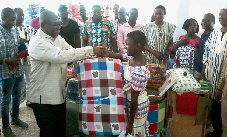 Mr Paul Asare Ansah presenting a mattress and other packages to one of the beneficiaries, Ms Ruth Siantey, who scored Aggregate seven in the 2018 BECE