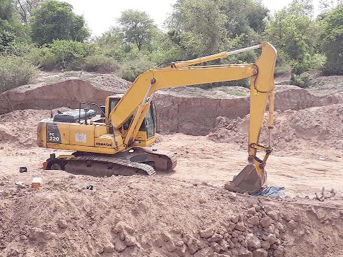 An excavator and a truck loaded with sand (inset) at  the sand winning site at Nawuni