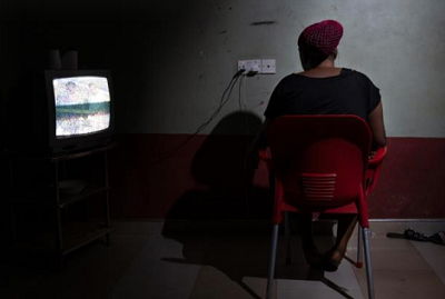 Blessing, a 26-year-old from Nigeria, inside the guesthouse where she lives with other 20 women who were also forced into prostitution [Francesco Bellina/Al Jazeera] 