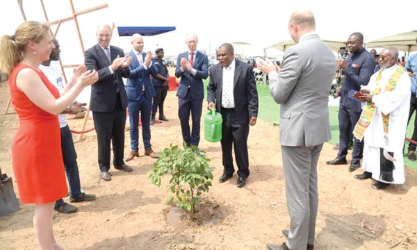 Dr Nurah Gyiele, the Minister of State in charge of Poultry, watering a tree to signify the sod cutting for the local animal feed mill. Looking on are some dignitories from the Dutch Embassyand Koudijs 