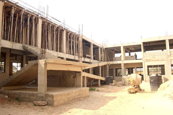 Mr Eric Kwabena Osae (2nd left), explaining a point to Mr Joshua Nii Bortey (2nd right),  and some officials during the inspection. INSET: The classroom block under construction. Picture: NII MARTEY M. BOTCHWAY