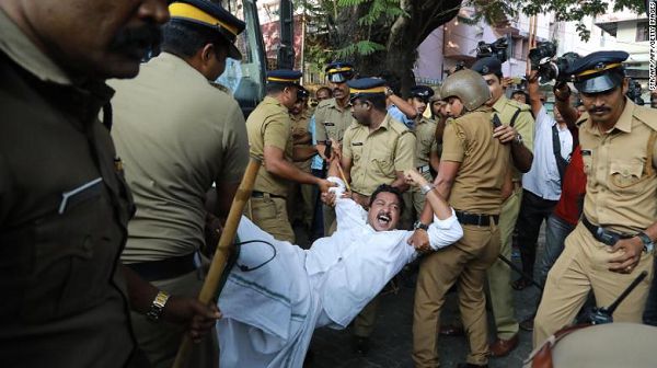 Police carry away a protester in Kochi, Kerala, after two women successfully entered a shrine they were previously barred from visiting.